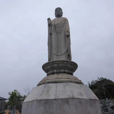 墓地に立つ石造の仏像