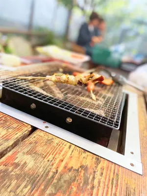 炭火で焼くイカの串焼き