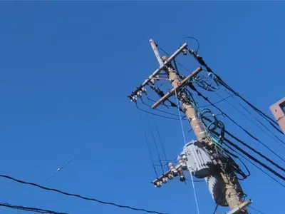 青空を背に見上げた電柱と電線
