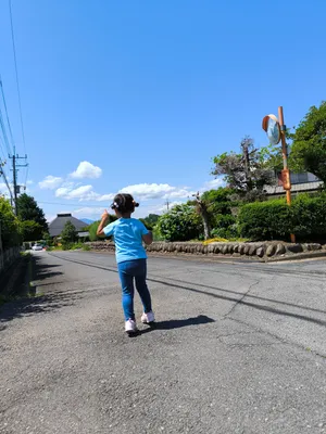 青空の下を元気に歩く少女