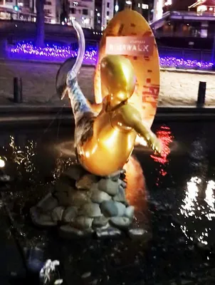 夜の金色の人魚像とイルミネーション