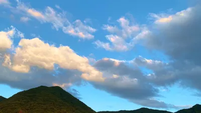 夕方の光に染まる山と雲