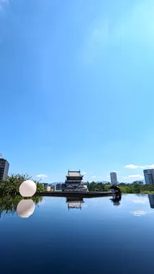 水を飲むカラスと水鏡に映る城